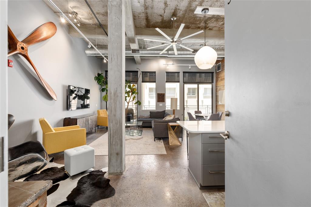 A modern industrial-style apartment features concrete ceilings, polished floors, and a large wooden propeller wall decoration — 302 SE BROADWAY STREET UNIT 330, OCALA, FL