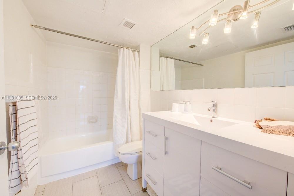 A bathroom features a white vanity, a large mirror, and a shower-tub combination — 1500 Bay Rd # 528S, Miami Beach FL 33139, MIAMI BEACH, FL