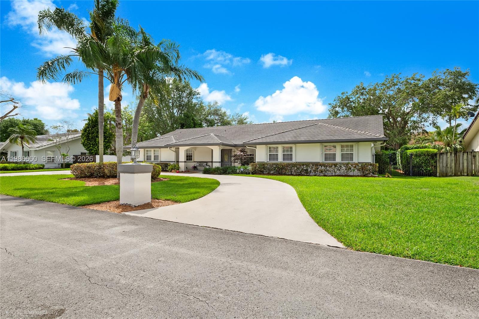 A single-story house with a white exterior, a gray tiled roof, and a curved concrete driveway — 10422 SW 121st St, Miami FL 33176, MIAMI, FL