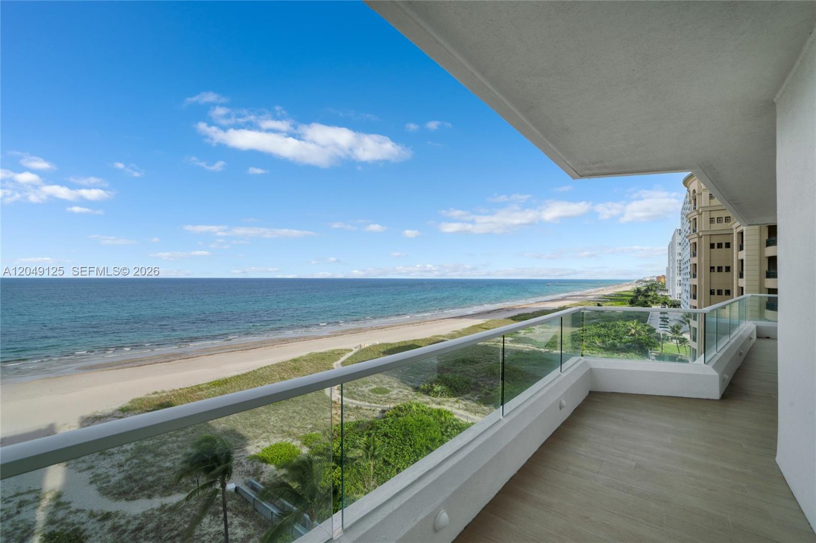 A balcony with a glass railing overlooks a sandy beach and the ocean — 2494 S Ocean Blvd, Boca Raton FL 33432, BOCA RATON, FL