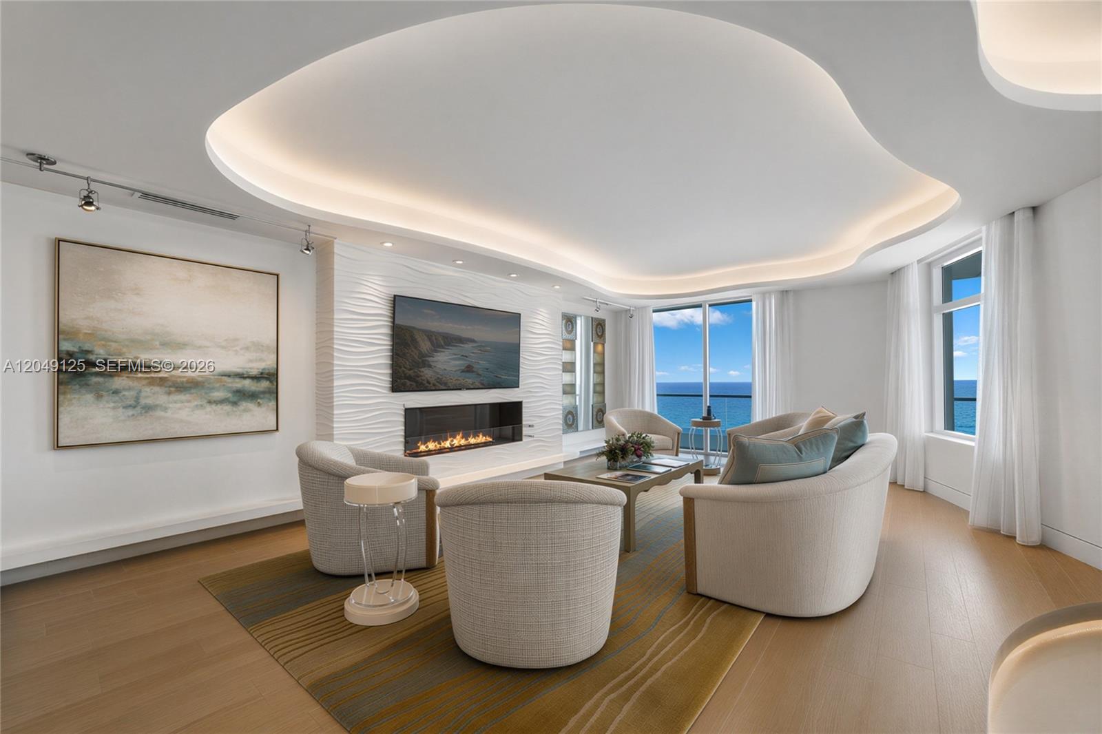 A modern living room features a curved ceiling, textured accent wall, fireplace, and ocean views — 2494 S Ocean Blvd, Boca Raton FL 33432, BOCA RATON, FL