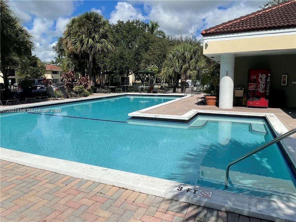 A swimming pool with a shallow end and a Coca-Cola vending machine on the patio — FORT LAUDERDALE, FL