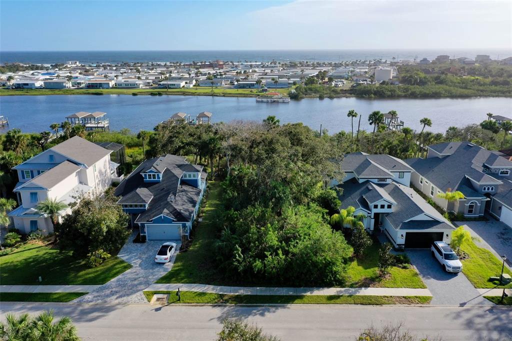 An aerial view shows a vacant wooded lot situated between two houses near a waterway — 41 S RIVERWALK DRIVE, PALM COAST, FL