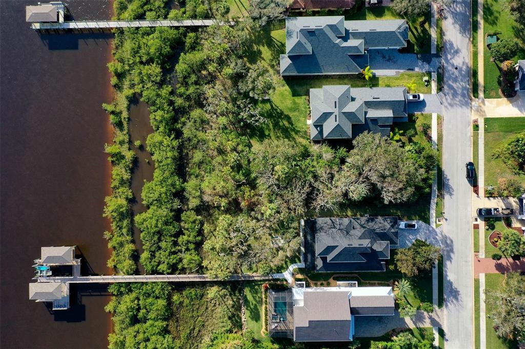An aerial view shows four waterfront houses with private docks along a tree-lined shore — 41 S RIVERWALK DRIVE, PALM COAST, FL