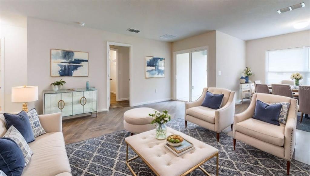 A living room features light-colored furniture, a patterned rug, and a glass-fronted console table — 18 SECOND PATH UNIT A & B, PALM COAST, FL