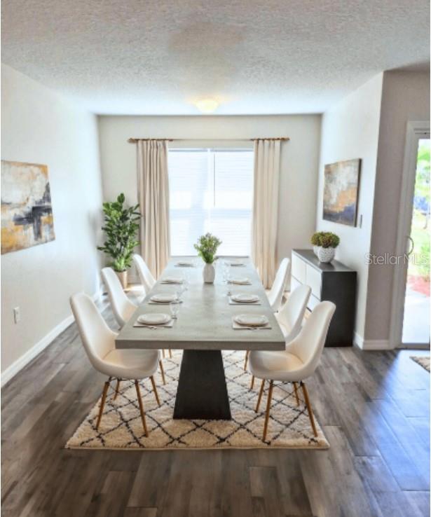 A dining room features a long rectangular table, eight white chairs, and wood-look flooring — 18 SECOND PATH UNIT A & B, PALM COAST, FL