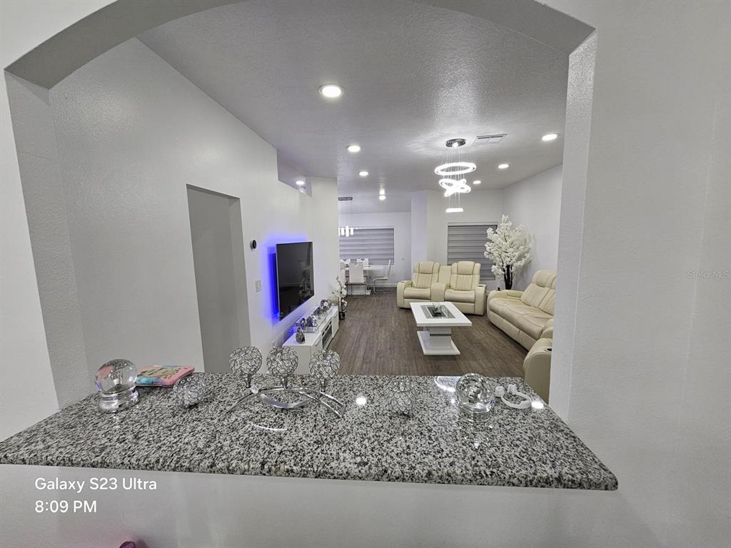 A view from a granite countertop looking into a living room with white furniture — 2256 TOWERING OAKS CIRCLE, SEFFNER, FL
