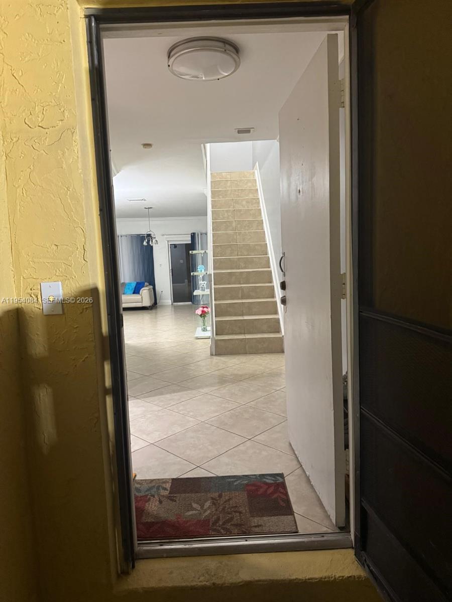 An open doorway reveals a tiled entryway with a staircase leading to an upper level — 8370 SW 154th Ave # 9, Miami FL 33193, MIAMI, FL