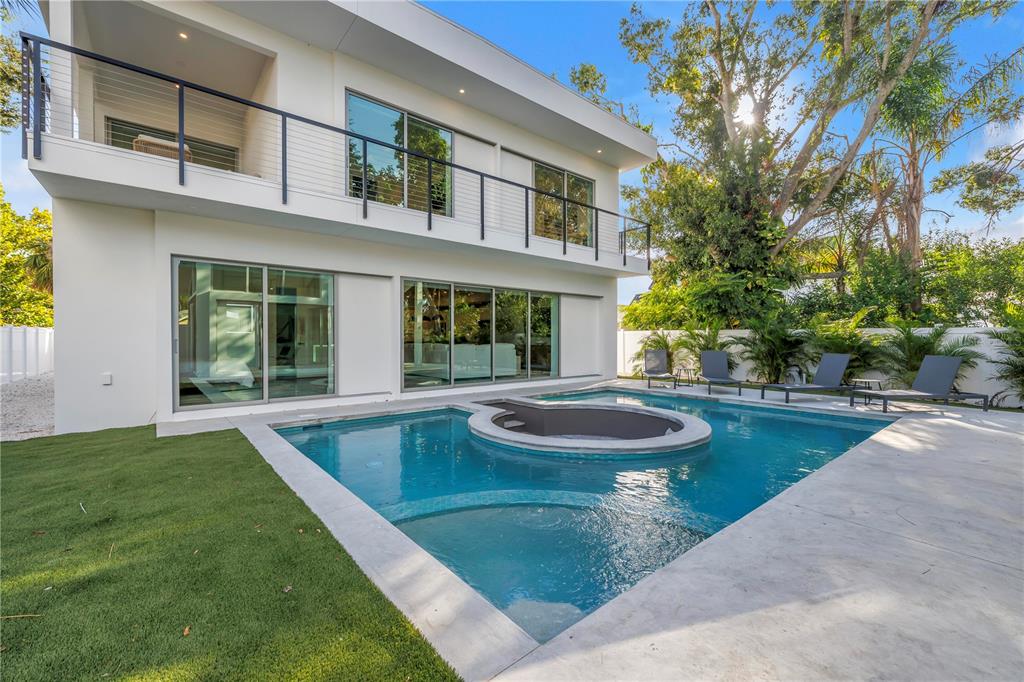 A modern two-story house features a backyard swimming pool with an integrated circular spa — 2564 ARLINGTON STREET, SARASOTA, FL