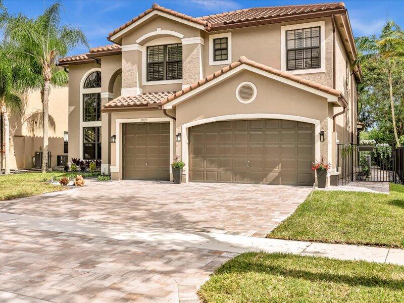 A two-story suburban house with a tan stucco exterior, tile roof, and three-car garage — 11737 Preservation Lane, Boca Raton FL 33498, BOCA RATON, FL