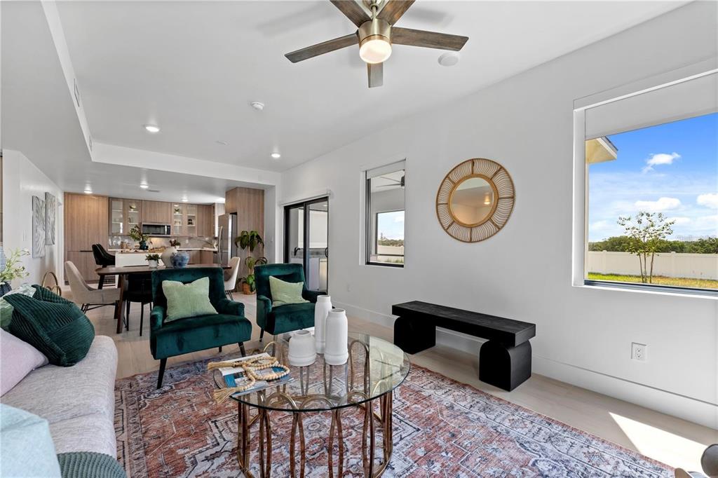 A living room features two green velvet chairs, a glass coffee table, and a dining area — 6390 CHORUS DRIVE, MASCOTTE, FL
