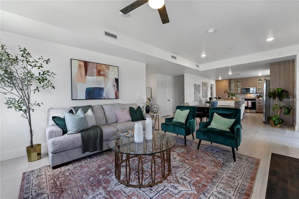 A living room features a gray sofa, two green armchairs, and a glass coffee table — 6390 CHORUS DRIVE, MASCOTTE, FL