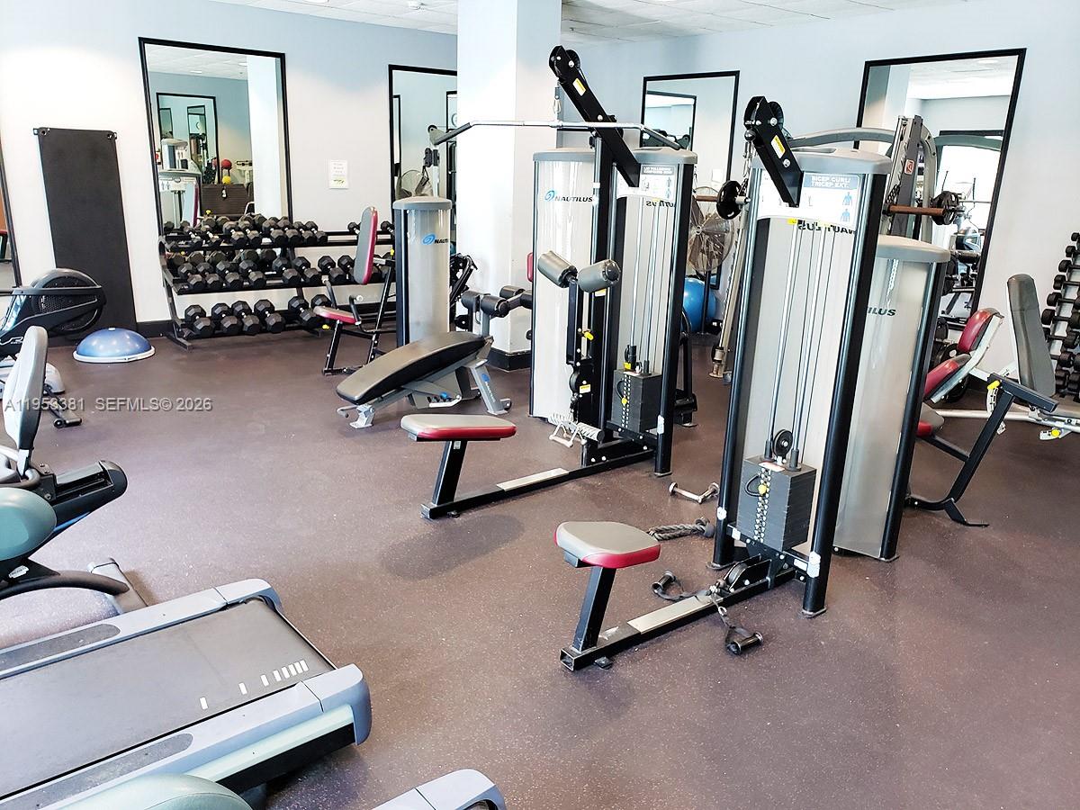 This gym features various Nautilus strength training machines, a dumbbell rack, and mirrored walls — 2665 SW 37th Ave # 611, Miami FL 33133, MIAMI, FL