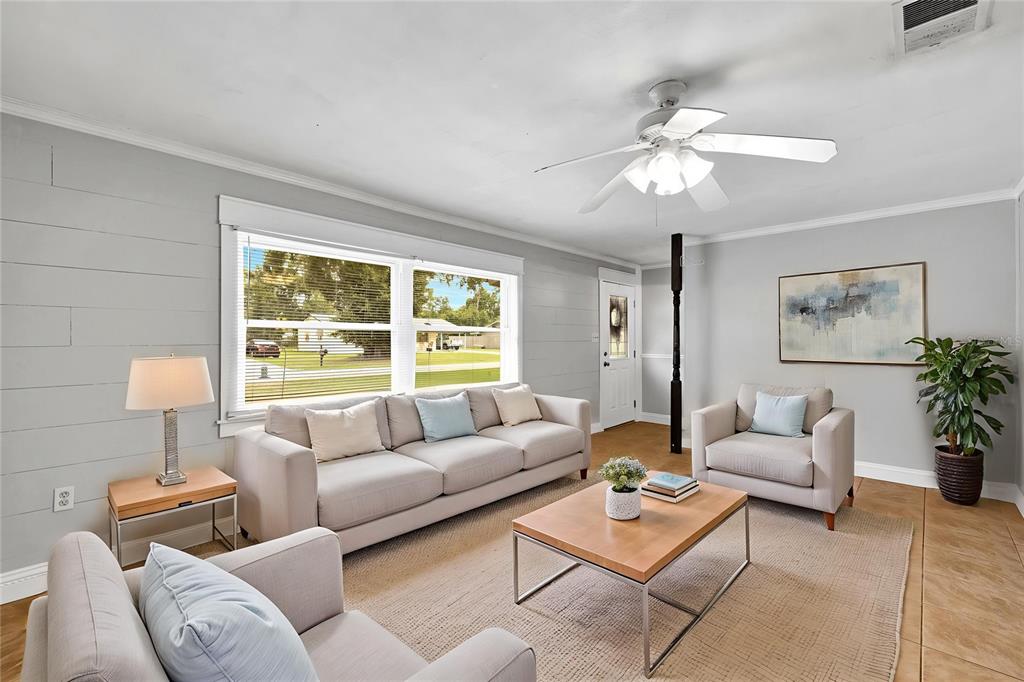 A living room features light gray shiplap walls, a ceiling fan, and neutral-toned furniture — 4314 LARK DRIVE, DOVER, FL