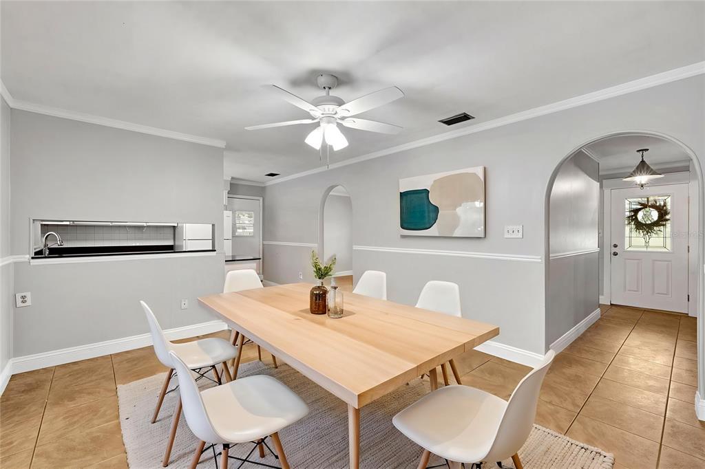 A dining room features a light wood table, white chairs, and an arched entryway — 4314 LARK DRIVE, DOVER, FL