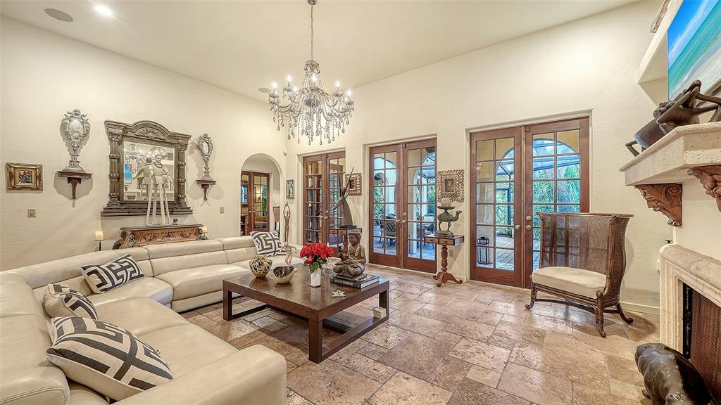 A living room features a white sectional sofa, a chandelier, and glass doors to a patio — 922 INDIAN BEACH DRIVE, SARASOTA, FL