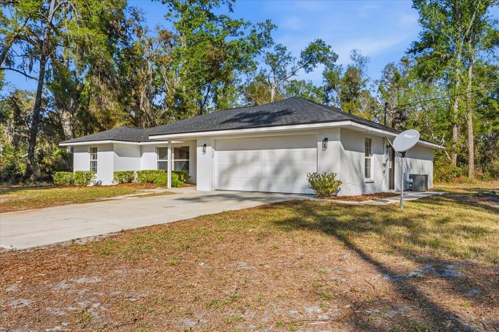 A white single-story house with a two-car garage and a dark shingled roof — 957 NE 354TH AVENUE, OLD TOWN, FL