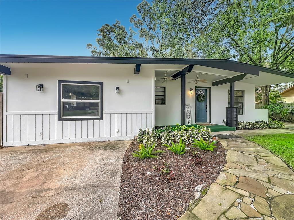 A single-story house features a white exterior, a stone walkway, and a covered front porch — 719 CHEROKEE CIRCLE, SANFORD, FL