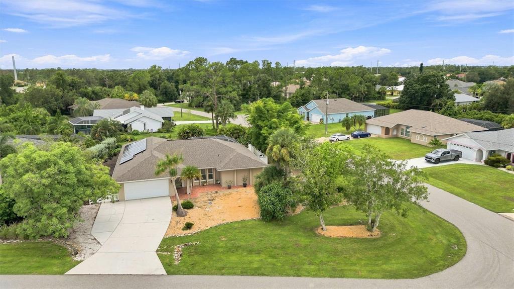 A galley kitchen features white cabinets, dark granite countertops, stainless steel appliances, and tiled floors — 317 SALVADOR DRIVE, PUNTA GORDA, FL