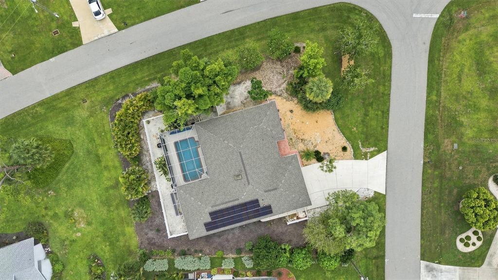 An aerial view shows a single-story house with a solar-paneled roof and a concrete driveway — 317 SALVADOR DRIVE, PUNTA GORDA, FL