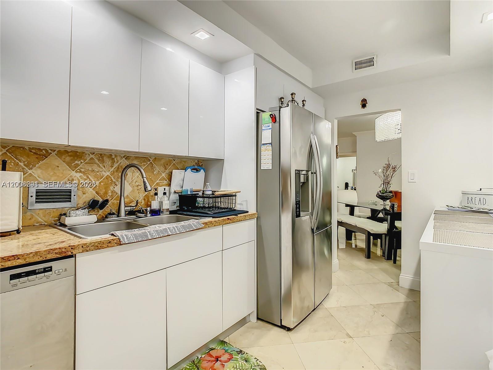 An outdoor swimming pool with a metal handrail is surrounded by a patio and palm trees — 10185 Collins # 308, Bal Harbour FL 33154, BAL HARBOUR, FL