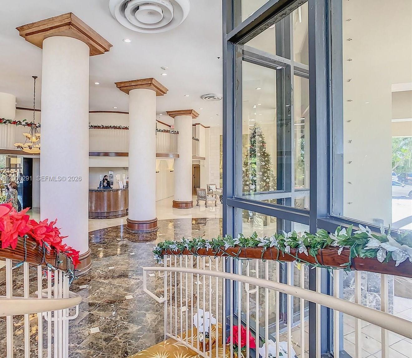 A dining room features a glass table, a bench, chairs, and a large crystal chandelier — 10185 Collins # 308, Bal Harbour FL 33154, BAL HARBOUR, FL