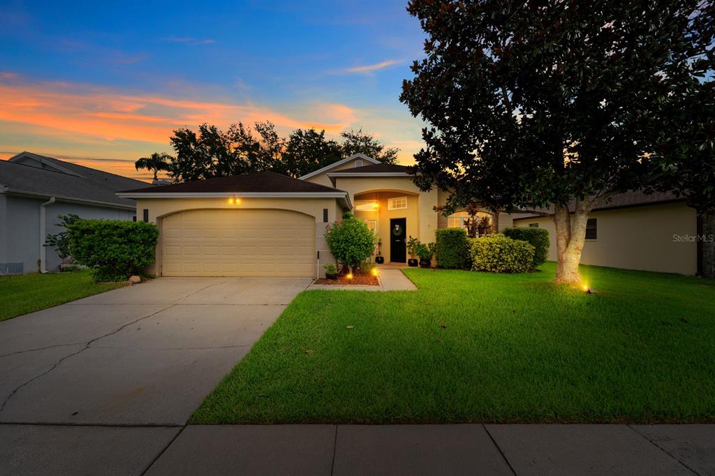 A single-story house with a two-car garage and a large tree in the front yard — 1518 WESTERLY DRIVE, BRANDON, FL