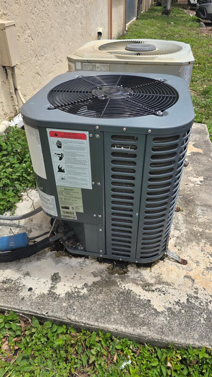 Two outdoor air conditioning condenser units sit on a concrete pad next to a wall — 6515 W 26th Dr # 38, Hialeah FL 33016, HIALEAH, FL