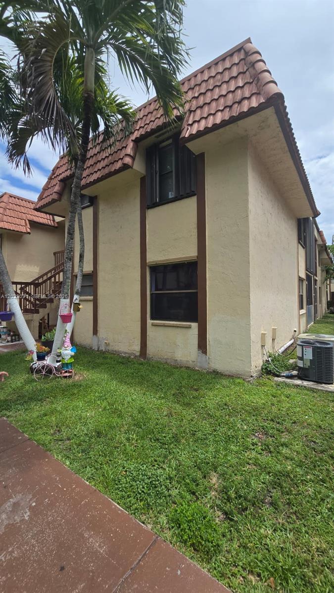 A two-story stucco building with a brown tile roof and an exterior staircase — 6515 W 26th Dr # 38, Hialeah FL 33016, HIALEAH, FL