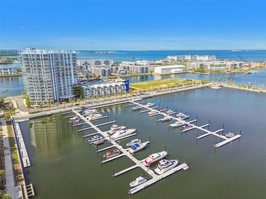 An aerial view shows a marina with docked boats next to a large apartment building — 5120 MARINA WAY UNIT 15005, TAMPA, FL