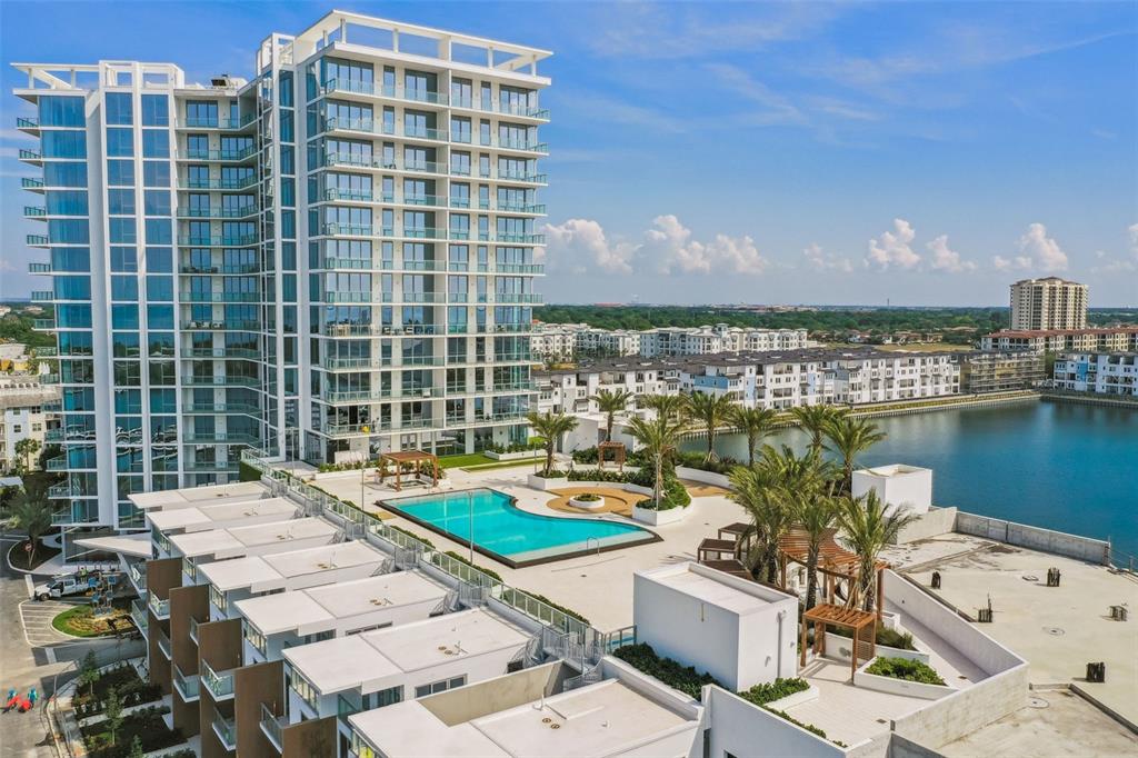 An aerial view of a modern high-rise apartment building with a pool and patio area — 5120 MARINA WAY UNIT 15005, TAMPA, FL