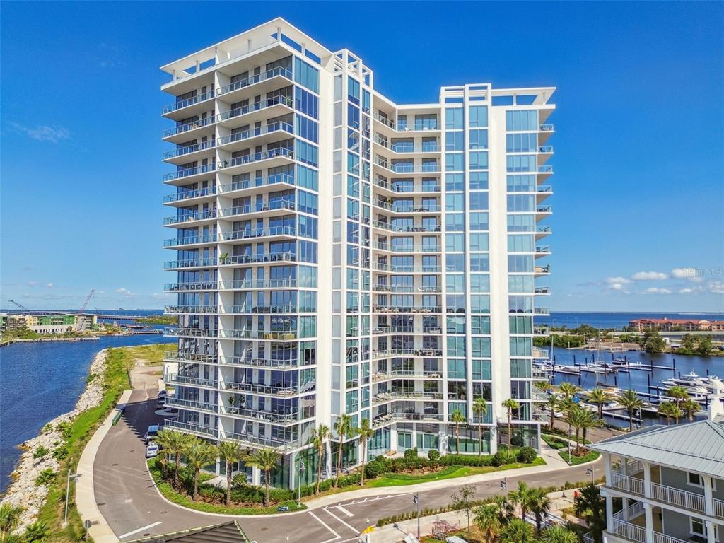 A tall, modern white residential high-rise building stands next to a marina and waterfront — 5120 MARINA WAY UNIT 15005, TAMPA, FL