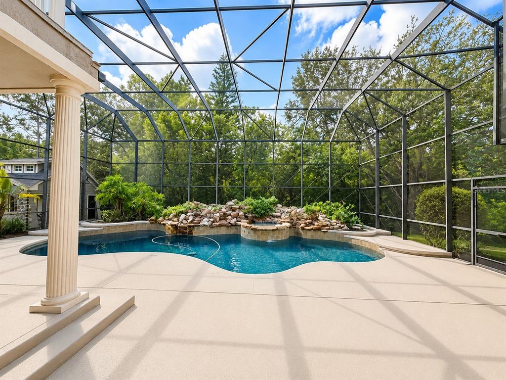 An aerial view shows a large house with a pool enclosure surrounded by dense trees — 3909 CASSIA DRIVE, ORLANDO, FL