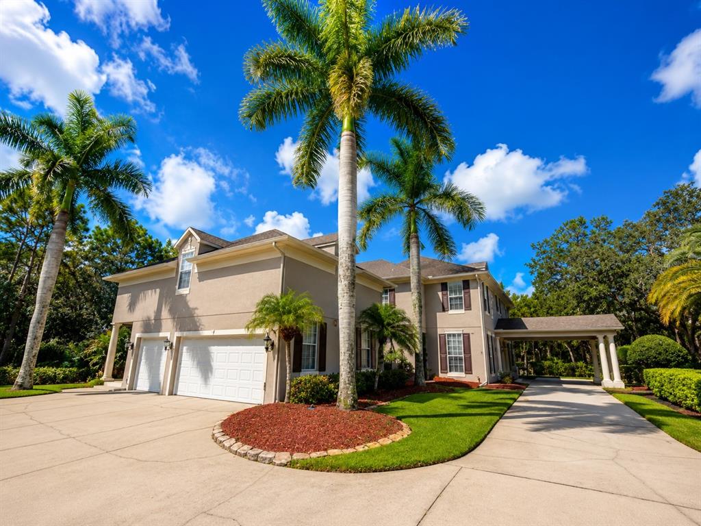 A screened-in swimming pool features a rock waterfall, a built-in spa, and lush landscaping — 3909 CASSIA DRIVE, ORLANDO, FL