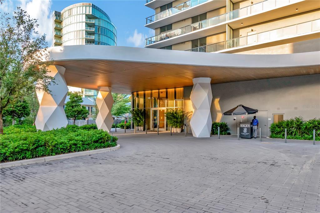 A modern building entrance features a large curved canopy supported by geometric white pillars — 3101 W BAYSHORE BOULEVARD UNIT 804, TAMPA, FL