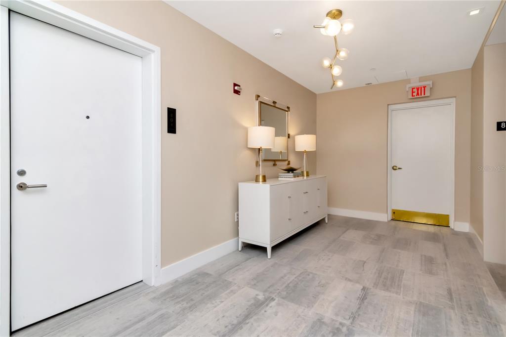 A hallway features light-colored tile flooring, a white console table with lamps, and two doors — 3101 W BAYSHORE BOULEVARD UNIT 804, TAMPA, FL