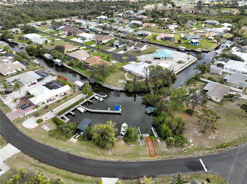 An aerial view shows a waterfront residential lot with a dock and boat slips — 2613 LEAR ROAD B LOT 14, ENGLEWOOD, FL