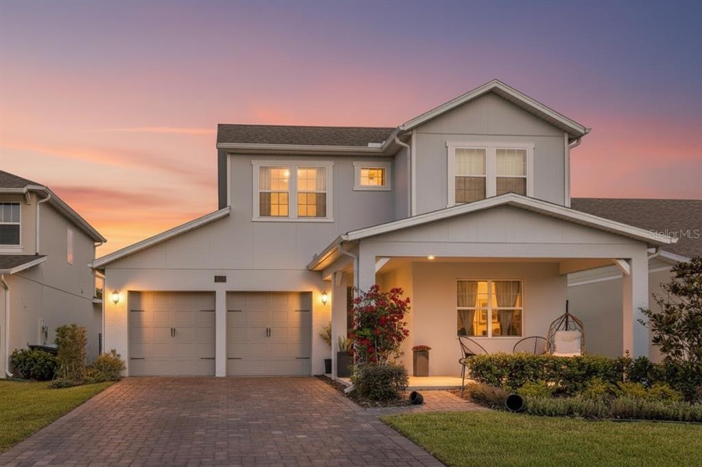 A two-story house with a paved driveway, two-car garage, and a covered front porch — 18907 RAWSON STREET, ORLANDO, FL