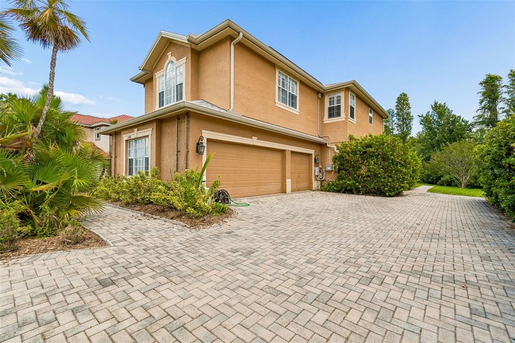 A two-story house with a tan stucco exterior and a paved driveway — 10746 CORY LAKE DRIVE, TAMPA, FL