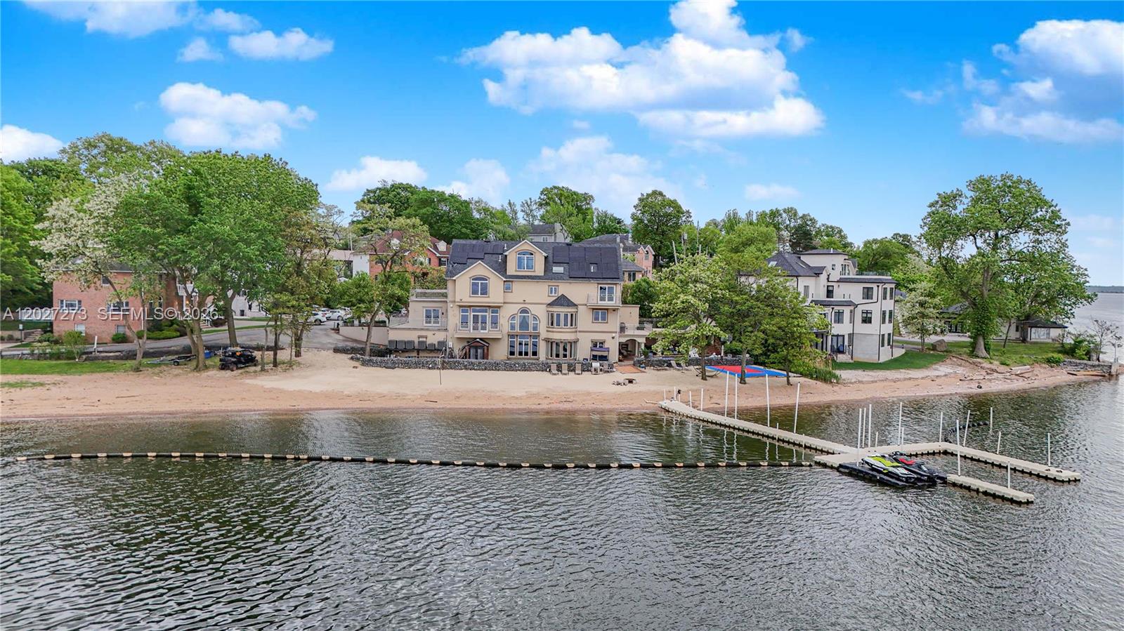 An aerial view shows a large waterfront house with a sandy beach and private dock — 30 Aviva Ct, NY 10307, NY