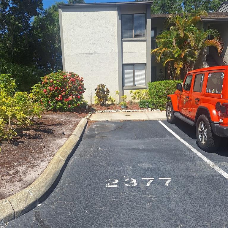 A parking space marked 2377 sits in front of a two-story apartment building exterior — 2377 LAKE HEATHER HEIGHTS COURT UNIT 2377, DUNEDIN, FL