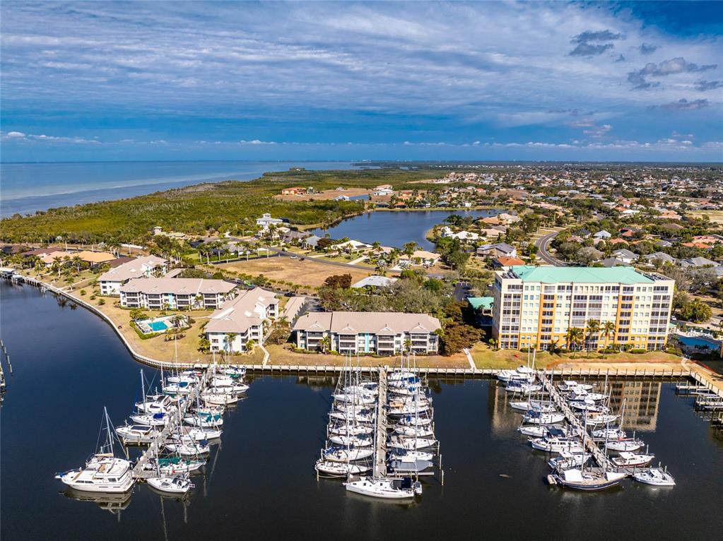 An aerial view of a marina with docked boats next to waterfront residential buildings — 3245 SUGARLOAF KEY ROAD UNIT 24C, PUNTA GORDA, FL