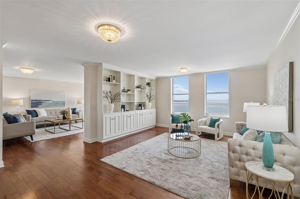 A bright living room features hardwood floors, a built-in bookshelf, and views of the water — 2403 S ARDSON PLACE UNIT 902B, TAMPA, FL
