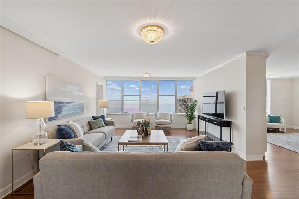 A living room features a sofa, coffee table, and large windows overlooking the ocean — 2403 S ARDSON PLACE UNIT 902B, TAMPA, FL