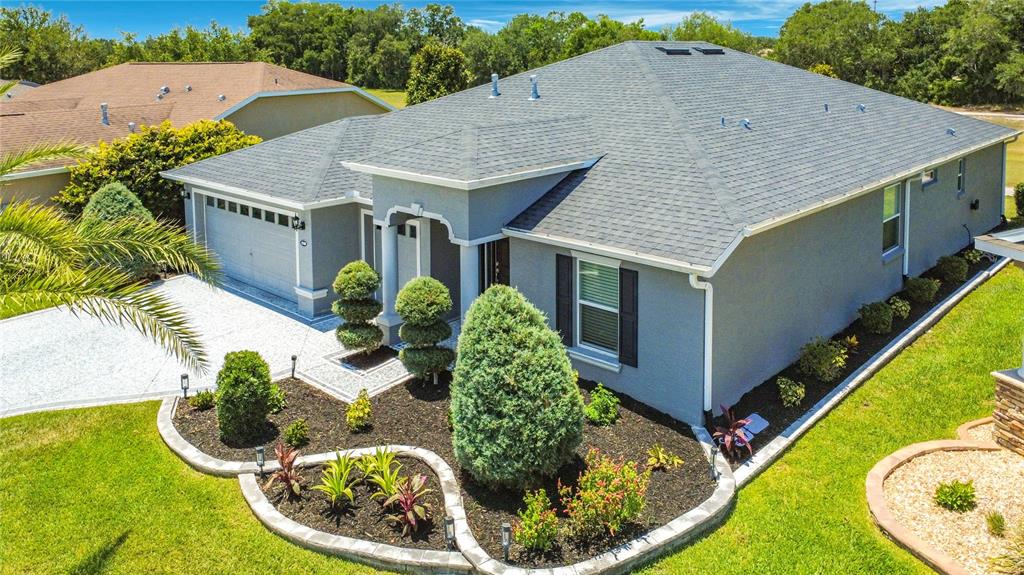 An aerial view shows a gray single-story house with a shingled roof and landscaped yard — 4240 JAMES RIVER CIRCLE, LEESBURG, FL
