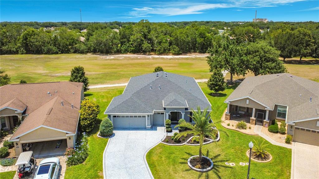 An aerial view shows a suburban house with a gray roof and a paved driveway — 4240 JAMES RIVER CIRCLE, LEESBURG, FL