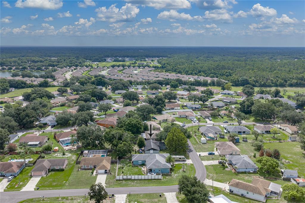 An aerial view shows a suburban neighborhood with a blue house marked by an arrow — 8054 KAITLIN CIRCLE, LAKELAND, FL