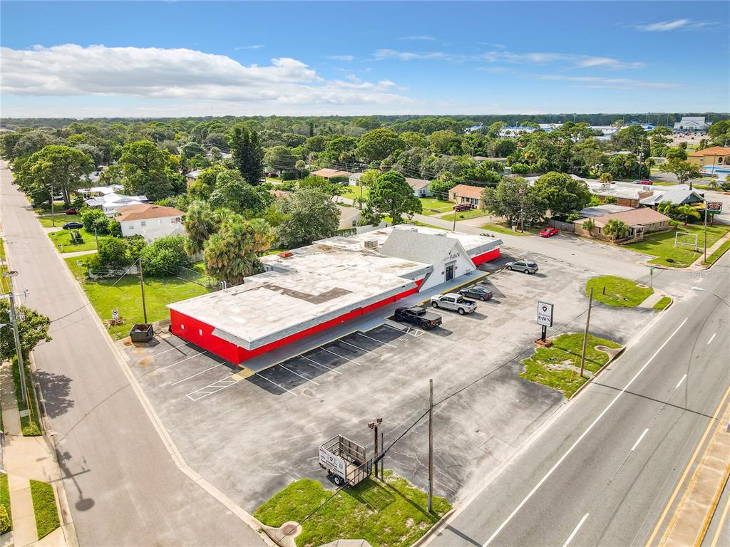 An aerial view shows a commercial building with a red exterior and a parking lot — 2300 S WASHINGTON AVENUE, TITUSVILLE, FL