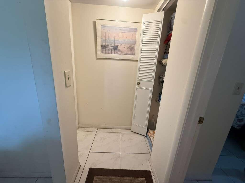 A small tiled alcove features a framed nautical print and an open louvered closet door — 213 Pine Hov Circle # D2, FL 33463, FL