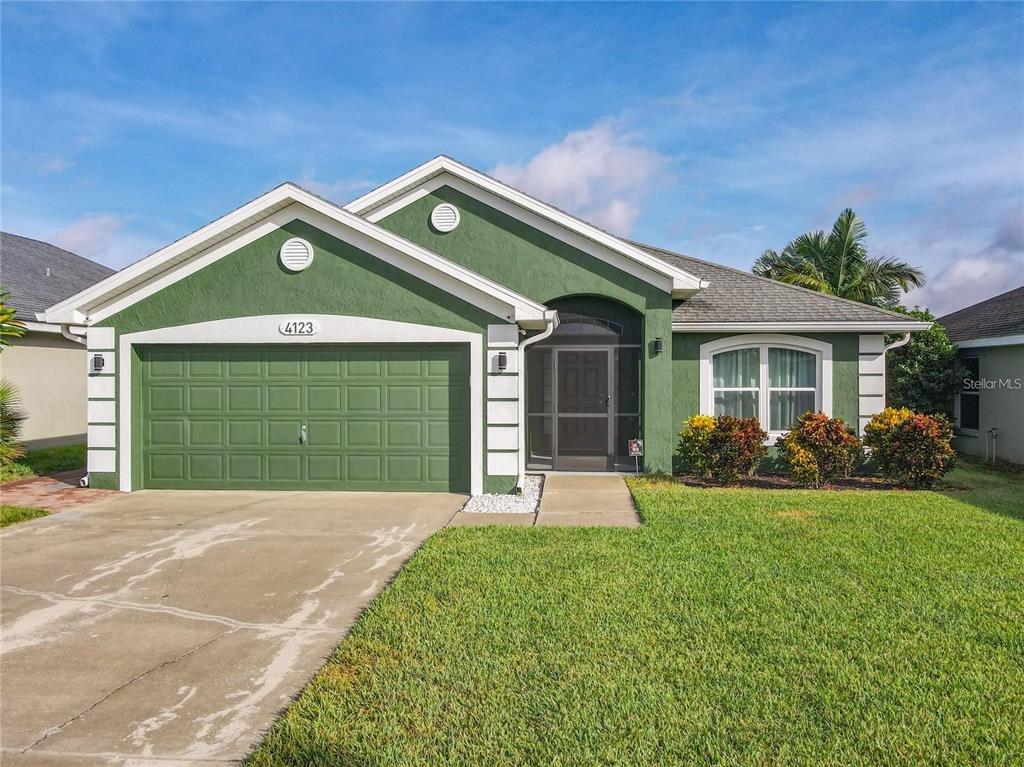 A green single-story house with a two-car garage and a front walkway — 4123 ISLAND LAKES DRIVE, WINTER HAVEN, FL